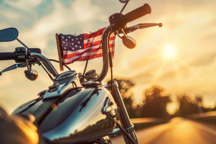 A motorcycle with an American Flag in front of it.