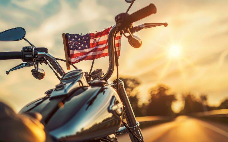 A motorcycle with an American Flag in front of it.